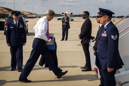 U.S. Secretary of State John Kerry (2nd L) looks down as he boards a plane to New Delhi at Andrews Air Force Base outside Washington July 29, 2014. REUTERS/Lucas Jackson