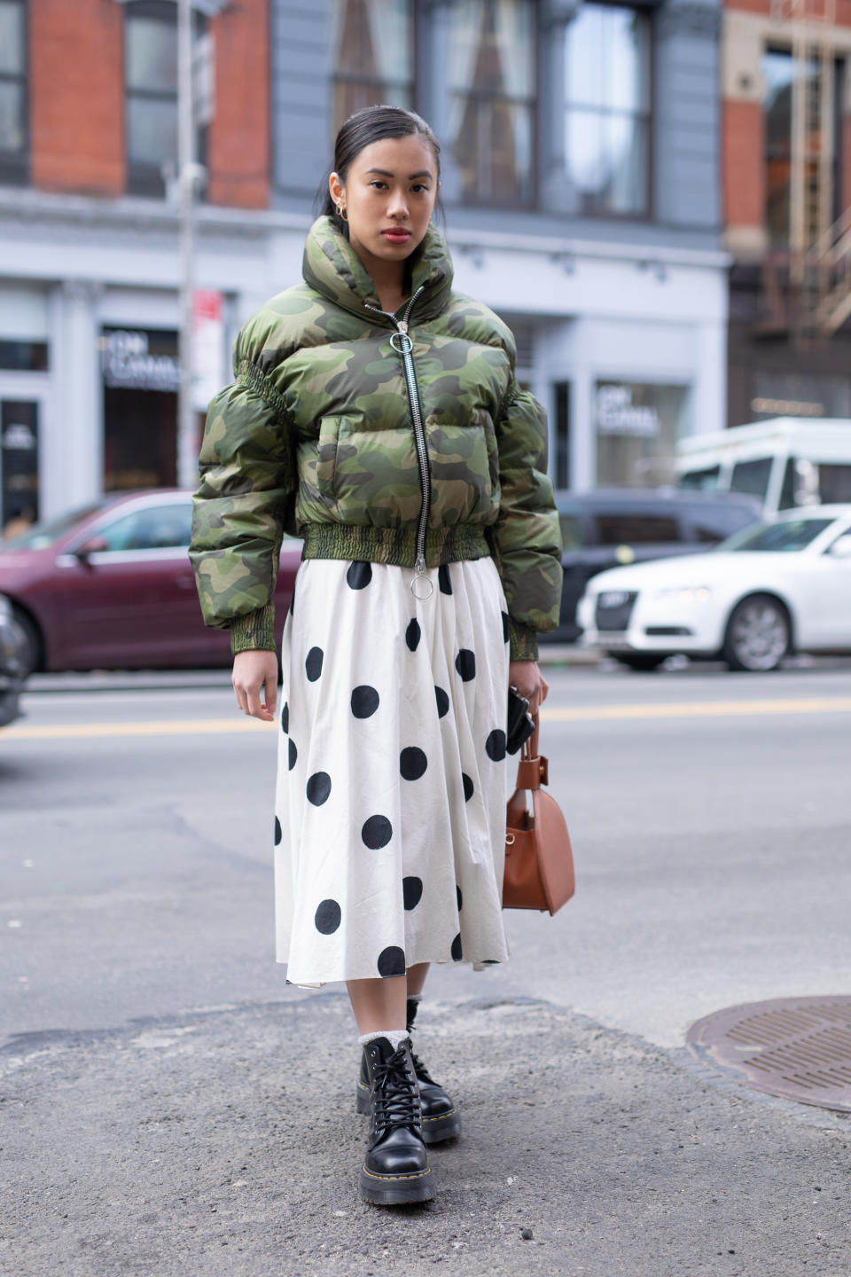 <p>A guest pairs biker boots with a camo jacket and a polka dot skirt during New York Fashion Week. <em>[Photo: Getty]</em> </p>