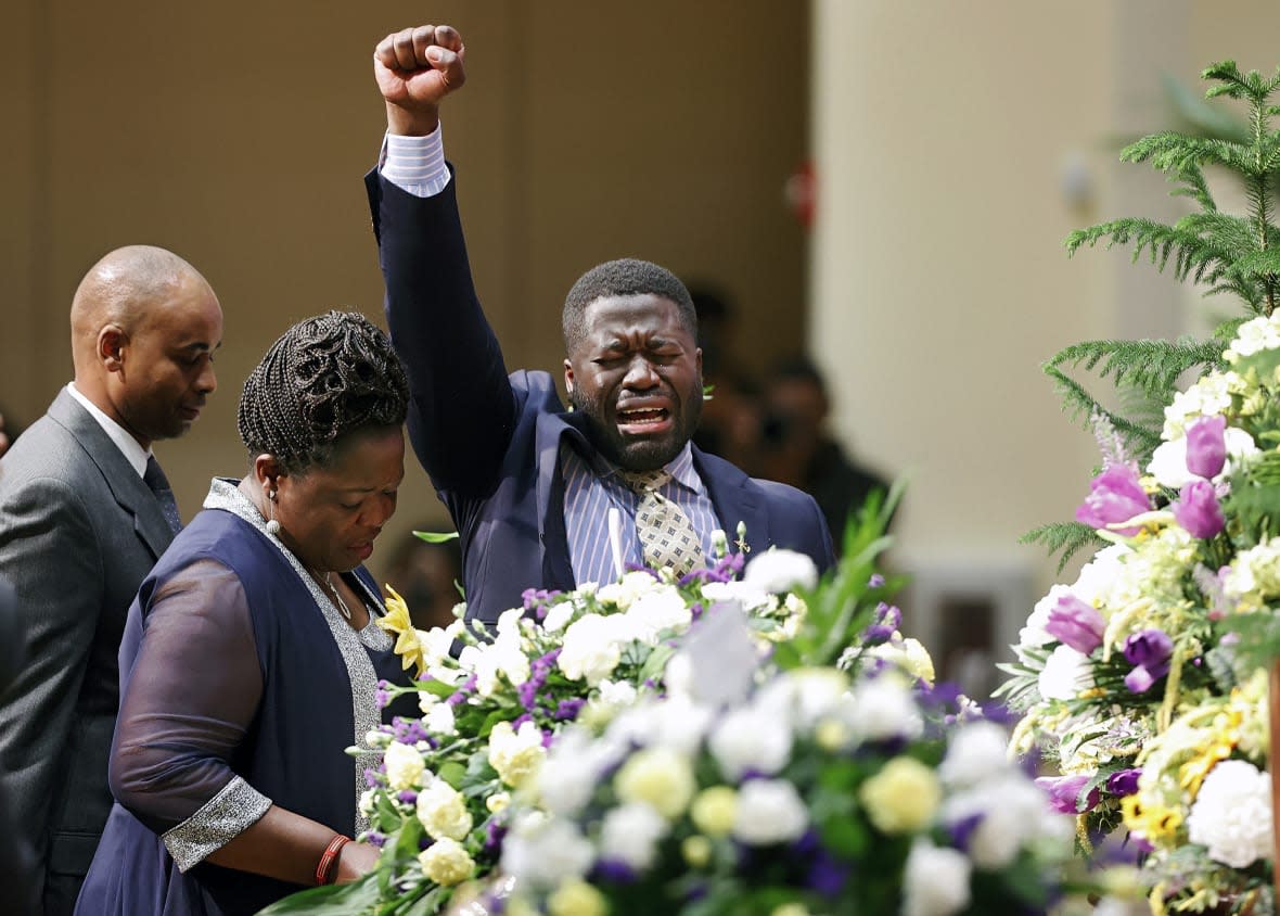 Caroline Ouko, center, and Leon Ochieng, right, mother and older brother of Irvo Otieno, react near his casket during the celebration of life for Irvo Otieno at First Baptist Church in North Chesterfield, Va., on Wednesday, March 29, 2023. (Eva Russo/Richmond Times-Dispatch via AP)