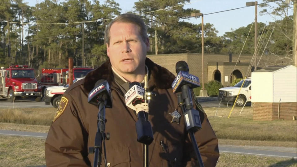 FILE - Carteret County Sheriff Asa Buck speaks with reporters in Carteret County, N.C., on Monday, Feb. 14, 2022. The families of four people – including three teens – who died in a February plane crash off the North Carolina coast are suing the companies that owned the plane and employed the pilot, who also died. The suit claims the pilot failed to properly fly the single-engine plane in weather conditions with limited visibility, making the firms liable. All eight people aboard the Pilatus PC-12/47 died when it descended into the Atlantic Ocean off the Outer Banks.(WCTI-TV via AP, File)