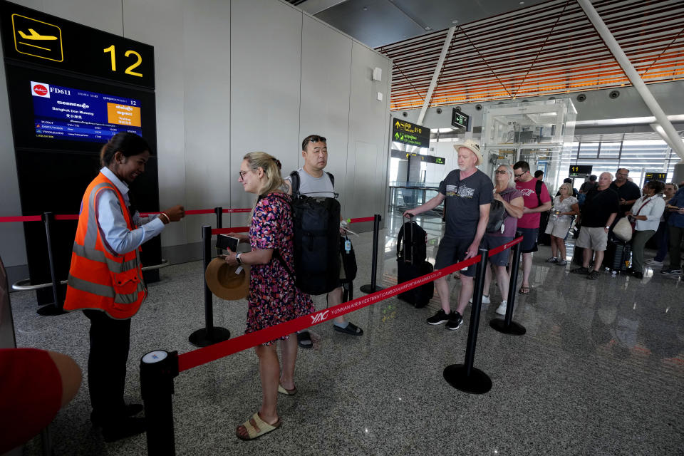 Tourists line up for boarding at the International Airport in Siem Reap province, Cambodia, as it opens Thursday, Nov. 16, 2023. The new airport can handle 7 million passengers a year, with plans to augment it to handle 12 million passengers annually from 2040. It was constructed under a 55-year build-operate-transfer (BOT) program between Cambodia and China. (AP Photo/Heng Sinith)