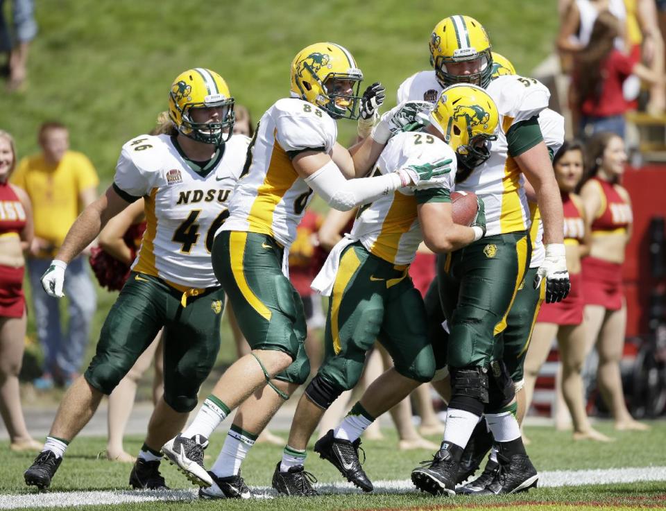 North Dakota State running back Chase Morlock (25) celebrates with teammates after scoring on a 66-yard touchdown run during the second half of an NCAA college football game against Iowa State, Saturday, Aug. 30, 2014, in Ames, Iowa. North Dakota State won 34-14. (AP Photo/Charlie Neibergall)