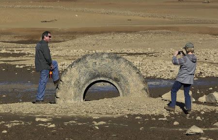 Visitors take photographs at the bottom of Folsom Lake, which is 17 percent of its capacity, in Folsom, California in this January 22, 2014 file photo. REUTERS/Robert Galbraith/Files