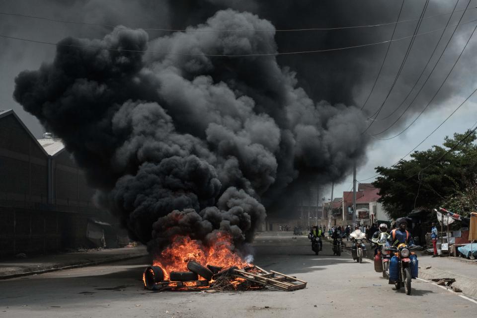 <p>Motorcyclists pass a burning tyre barricade following a demonstration by Kenyan opposition party National Super Alliance (NASA) supporters on Nov. 17, 2017 in Nairobi. (Photo: Yasuyoshi Chiba/AFP/Getty Images) </p>