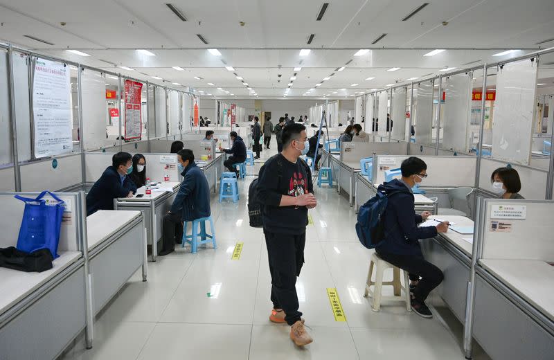 People wearing face masks attend a job fair in Hangzhou