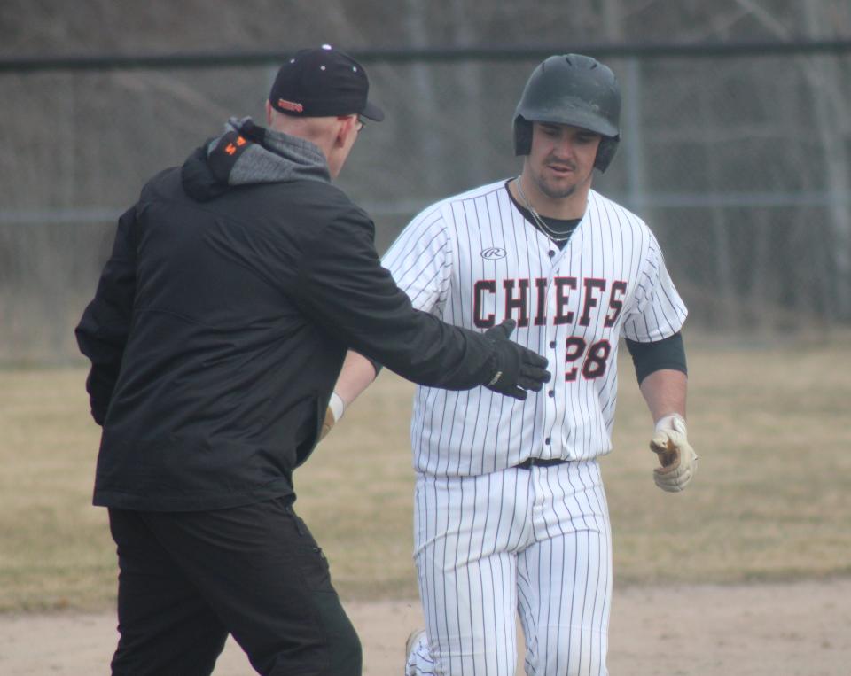 Cheboygan junior Sean Postula (28) gets congratulated by coach Kevin Baller after blasting a grand slam home run during game one of a home baseball doubleheader against Harbor Springs on Friday.