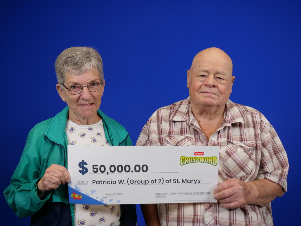 Retired duo hold a $50,000 lottery cheque. 