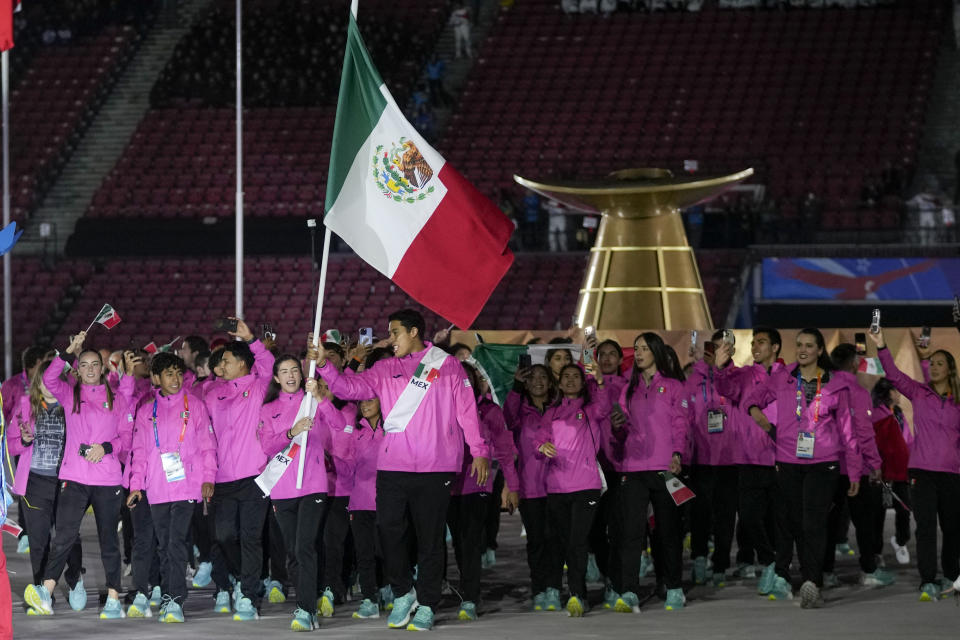 Karina Esquer and Carlos Sansores of Mexico carry their country's flag during the opening ceremony of the Pan American Games at the National Stadium in Santiago, Chile, Friday, Oct. 20, 2023. (AP Photo/Fernando Vergara)