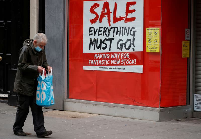 FILE PHOTO: A man walks past a closed shop advertising a sale amid the outbreak of the coronavirus disease (COVID-19) in Liverpool