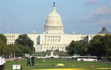 Police officers investigate the scene where a man set himself on fire in front of the U.S. Capitol building on the U.S. National Mall in Washington, October 4, 2013. REUTERS/Gary Cameron