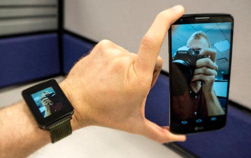 Smartwatch and phone showing an image of the author taking a picture