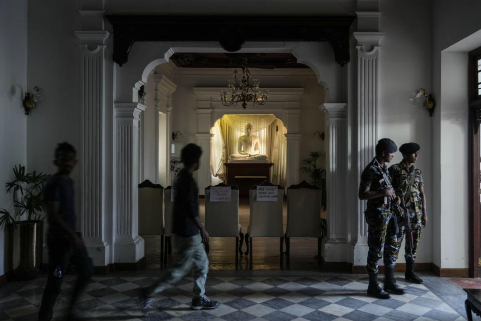 Army soldiers stand guard as protesters leave prime minister Ranil Wickremesinghe's office building in Colombo, Sri Lanka, Thursday, July 14, 2022. Sri Lankan protesters retreated from government buildings they seized and military troops reinforced security at the Parliament on Thursday, establishing a tenuous calm in a country in both economic meltdown and political limbo.(AP Photo/Rafiq Maqbool)