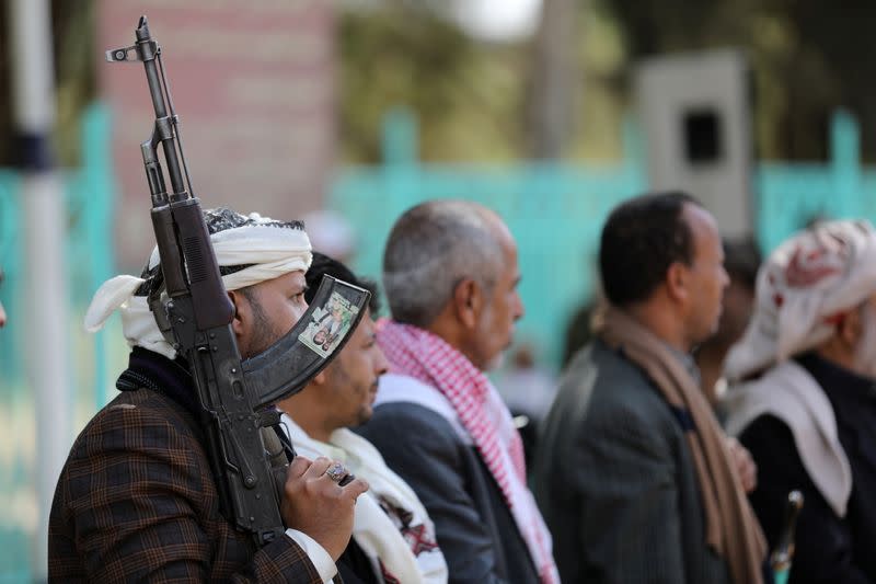 Houthi supporter holds a rifle as he attends a ceremony held to send donated clothes to Houthi fighters at the frontlines against government forces, in Sanaa