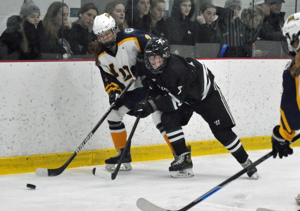 Notre Dame Academy's Sarah White, left, and Duxbury's Caylee Higgins, left, battle for the puck during the Tenney Cup Hockey Tournament at The Bog in Kingston, Monday, Dec. 26, 2022.