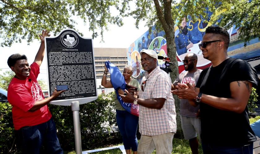 Sam Collins III, left, and others celebrate at the Juneteenth historical marker in Galveston after President Joe Biden signed the Juneteenth National Independence Day Act into law on Thursday, June 17, 2021. (Jennifer Reynolds/The Galveston County Daily News via AP)