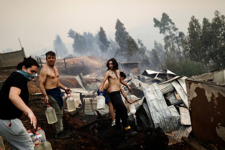 Los residentes intentan extinguir el fuego mientras un incendio forestal quema parte de las zonas rurales de Tomé, Chile