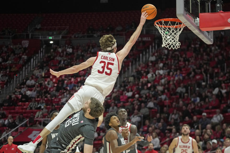 Utah center Branden Carlson (35) goes to the basket as Washington State forward Oscar Cluff (45) defends during the second half of an NCAA college basketball Friday, Dec. 29, 2023, in Salt Lake City. (AP Photo/Rick Bowmer)