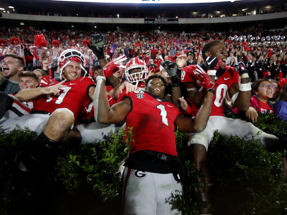 Georgia wide receiver George Pickens (1) celebrates with Eli Wolf, left, and J.R. Reed (20) after defeating Texas A&M 19-13 in an NCAA college football game Saturday, Nov. 23, 2019, in Athens, Ga. (AP Photo/John Bazemore)