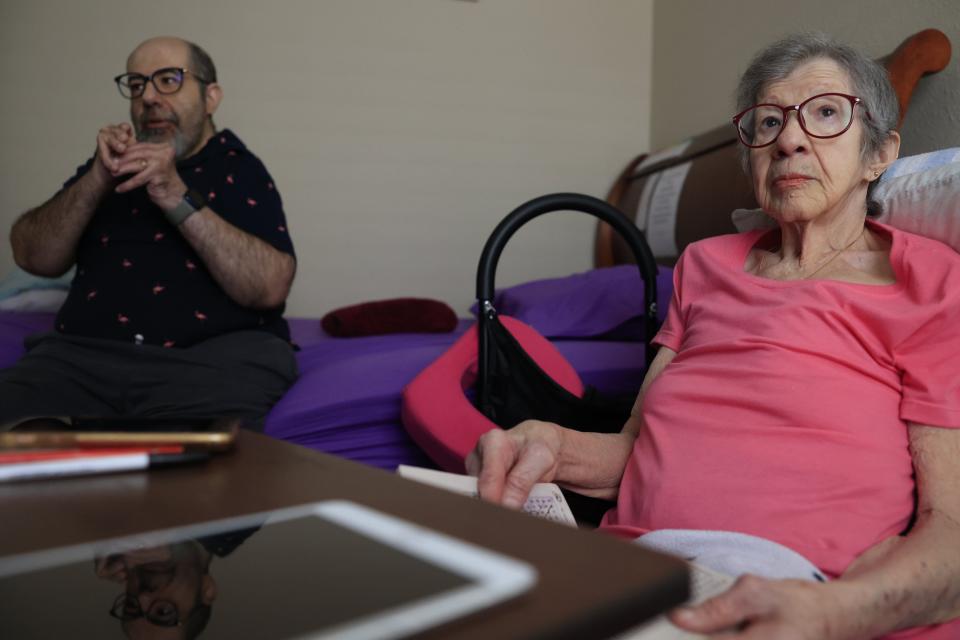 Hector De Jesus speaks with an ElderSource social worker alongside his mother, Alba De Jesus, at their St. Augustine home. Alba has dementia and her son is her primary caregiver.