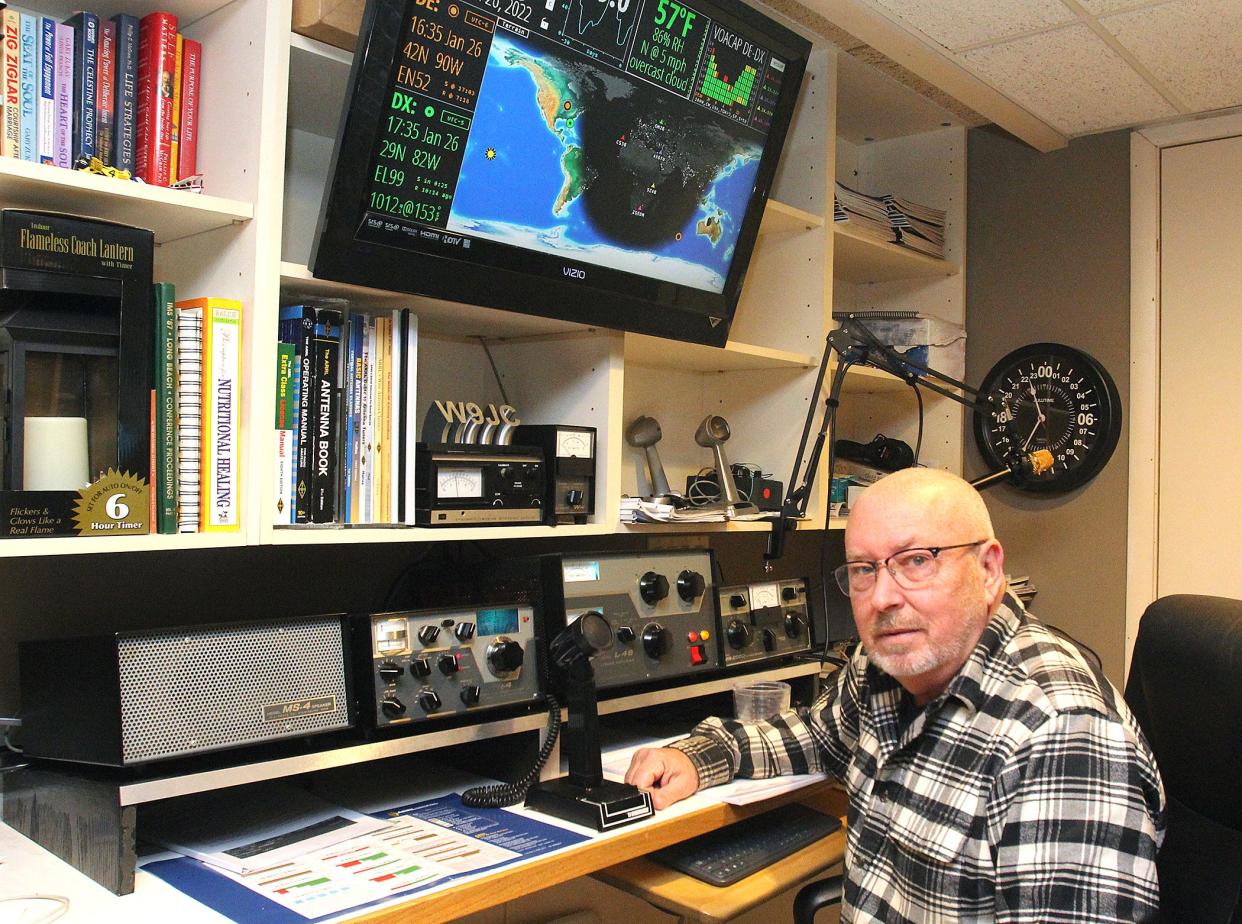 John Mitchell sits in front of his amateur "ham" radio setup, including a screen showing a map of the world and designated places he can reach and speak with other ham radio operators on Wednesday, Jan. 26, 2022, at his home in Freeport.