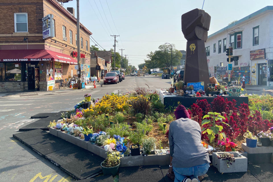 Rozenia Fuller, a pastor at Good News Baptist Church in north Minneapolis, kneels before a sculpture and small garden at the George Floyd memorial site on Tuesday, Sept. 22, 2020. Vice President Mike Pence brings President Donald Trump’s law-and-order campaign message to Minneapolis on Thursday, planning a “listening session” with a “Cops for Trump” group, as well as with community members the Trump campaign says have suffered from crime and “violent extremism” in the city. (Mohamed Ibrahim/AP/Report for America)