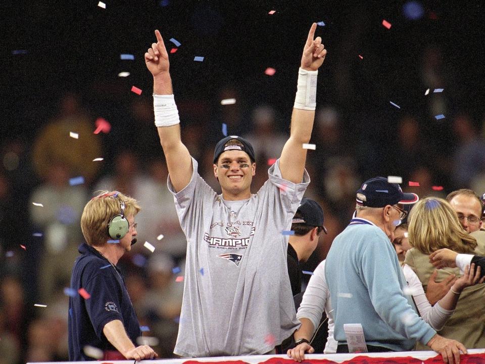 Tom Brady raises his hands as confetti falls after the Super Bowl in 2002.
