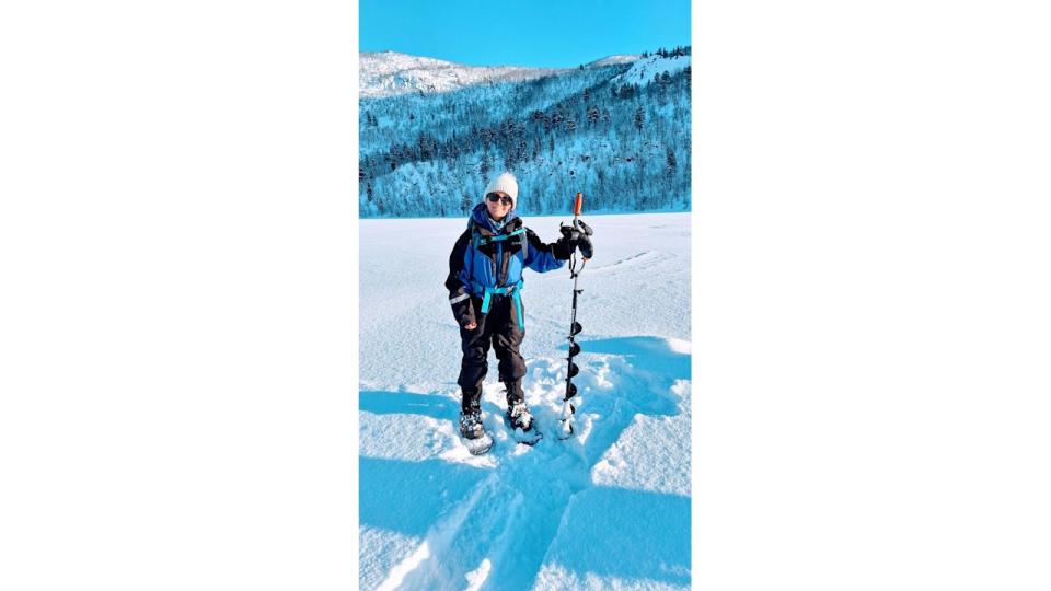 woman standing in the snow with a walking pole