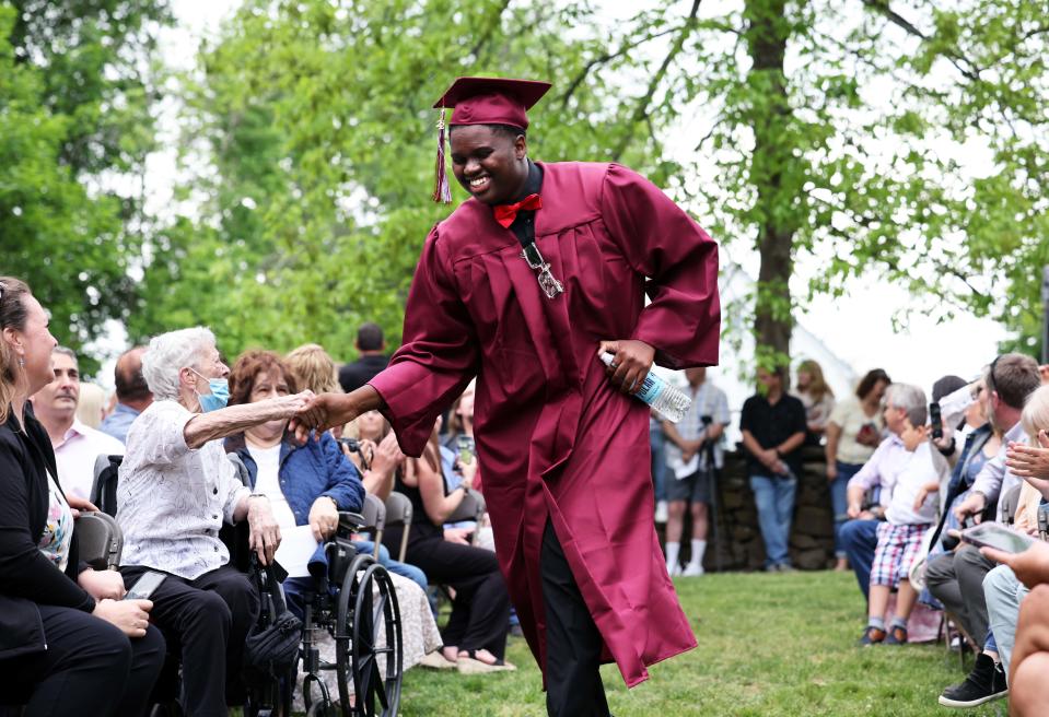 Jason Moreno shakes hand with a guest during West Bridgewater Middle-Senior High School graduation at War Memorial Park on Friday, May 27, 2022.  