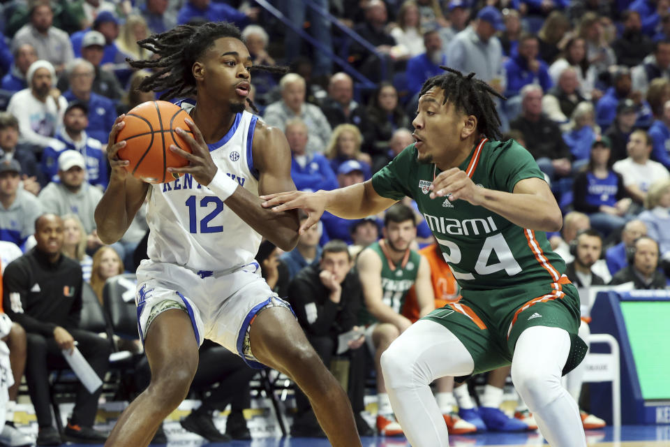Kentucky's Antonio Reeves (12) looks for an opening on Miami's Nijel Pack (24) during the first half of an NCAA college basketball game in Lexington, Ky., Tuesday, Nov. 28, 2023. (AP Photo/James Crisp)