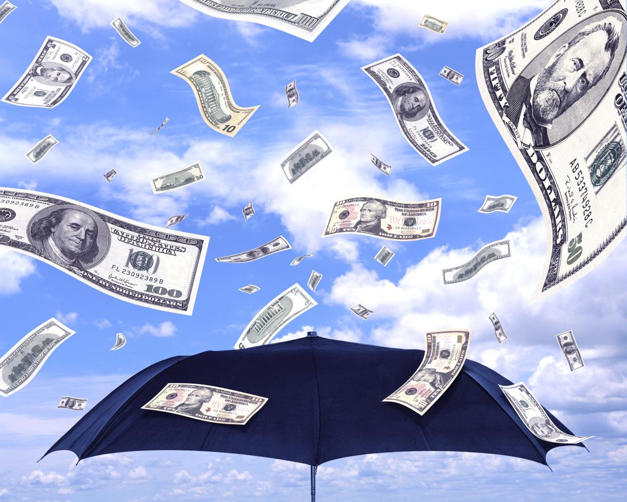 Geldregen aus Dollarscheinen auf einen Regenschirm fallend