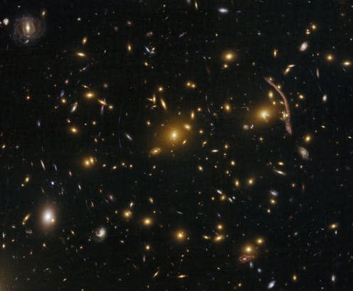 <span class="caption">Gravitational lensing (arcs and streaks in the picture) in the galaxy cluster Abell 370.</span> <span class="attribution"><span class="source">NASA/ESA</span></span>