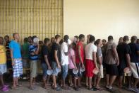 Prisoners line up for a meal in the renovated wing of the Najayo prison in San Cristobal, May 13, 2014. Ten years after the country opened its first prison designed with a focus on education and clean living conditions and staffed by graduates from a newly created academy for penitentiary studies, the New Model of Prison Management is gaining recognition from other countries in the region trying to reduce prison populations and cut recidivism rates. Picture taken May 13, 2014. REUTERS/Ricardo Rojas (DOMINICAN REPUBLIC - Tags: CRIME LAW POLITICS SOCIETY)