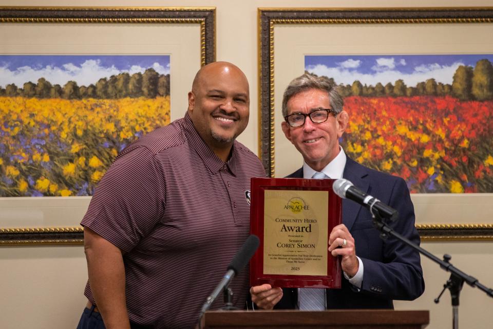 President and CEO of the Apalachee Center Jay Reeve, right, presents Senator Corey Simon with a Community Hero award from the Apalachee Center on Monday, July 31, 2023.