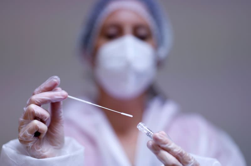 A medical worker holds a test tube after administering a nasal swab to a patient at a coronavirus disease (COVID-19) testing centre in Les Sorinieres