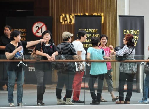 People stand outside the Marina Sands Casino in Singapore in June last year. Singapore is set to overtake Las Vegas as the world's second-largest gambling hub this year, a US gaming industry head said Tuesday, as Asia cements its place as a major betting market