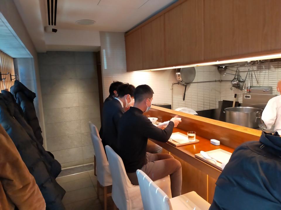 Chukasoba Ginza Hachigou ramen bar view of four seats, two people eating at the end of the bar