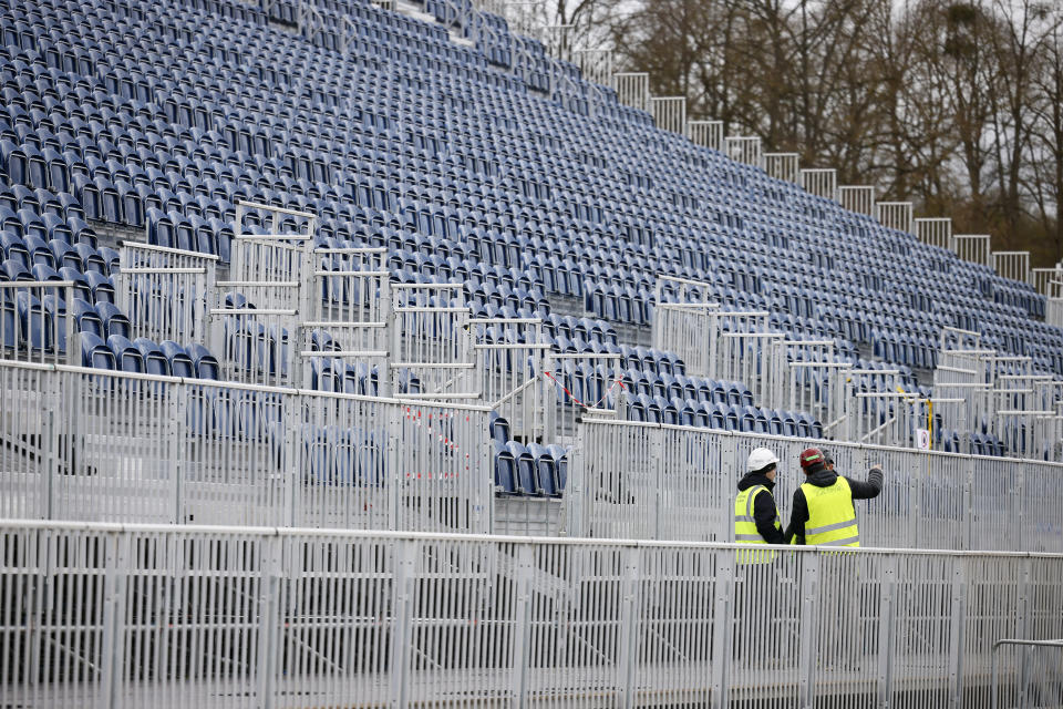 Workers discuss in the stands to watch the equestrian sports, Friday, March 29, 2024 in the park of the Chateau de Versailles, west of Paris. The site will be the venue for equestrian sports at the Paris 2024 Olympic Games. (AP Photo/Thomas Padilla)