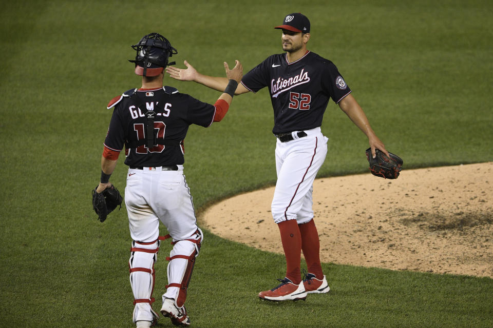 Washington Nationals relief pitcher Brad Hand (52) and catcher Yan Gomes (10) celebrate after a baseball game against the Baltimore Orioles, Friday, May 21, 2021, in Washington. (AP Photo/Nick Wass)