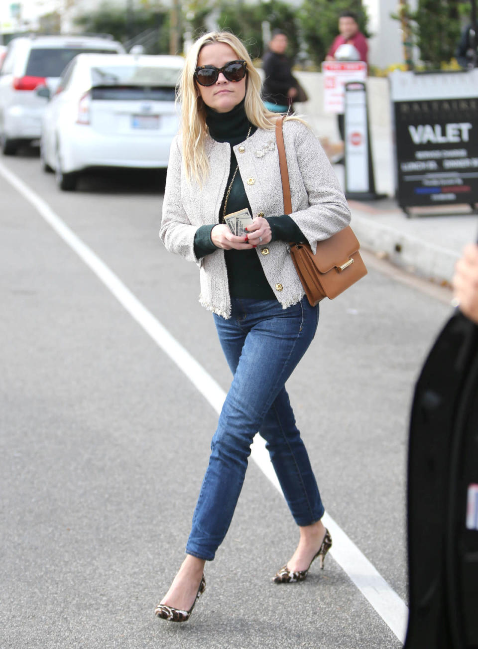 Reese Witherspoon wears a boucle cardigan, green turtleneck, blue jeans, and leopard print pumps on Dec. 10, 2015 in Los Angeles, California.