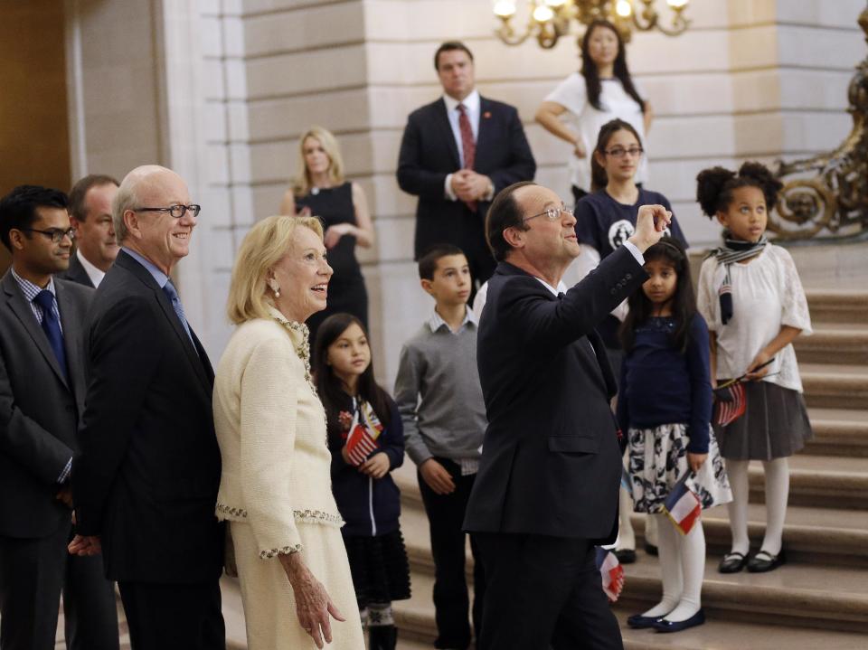 French president Francois Hollande, at right, waves as he arrives at city hall on Wednesday, Feb. 12, 2014, in San Francisco. The French president visited San Francisco to meet politicians, lunch with Silicon Valley tech executives and inaugurate a new U.S.-French Tech Hub. (AP Photo/Marcio Jose Sanchez)