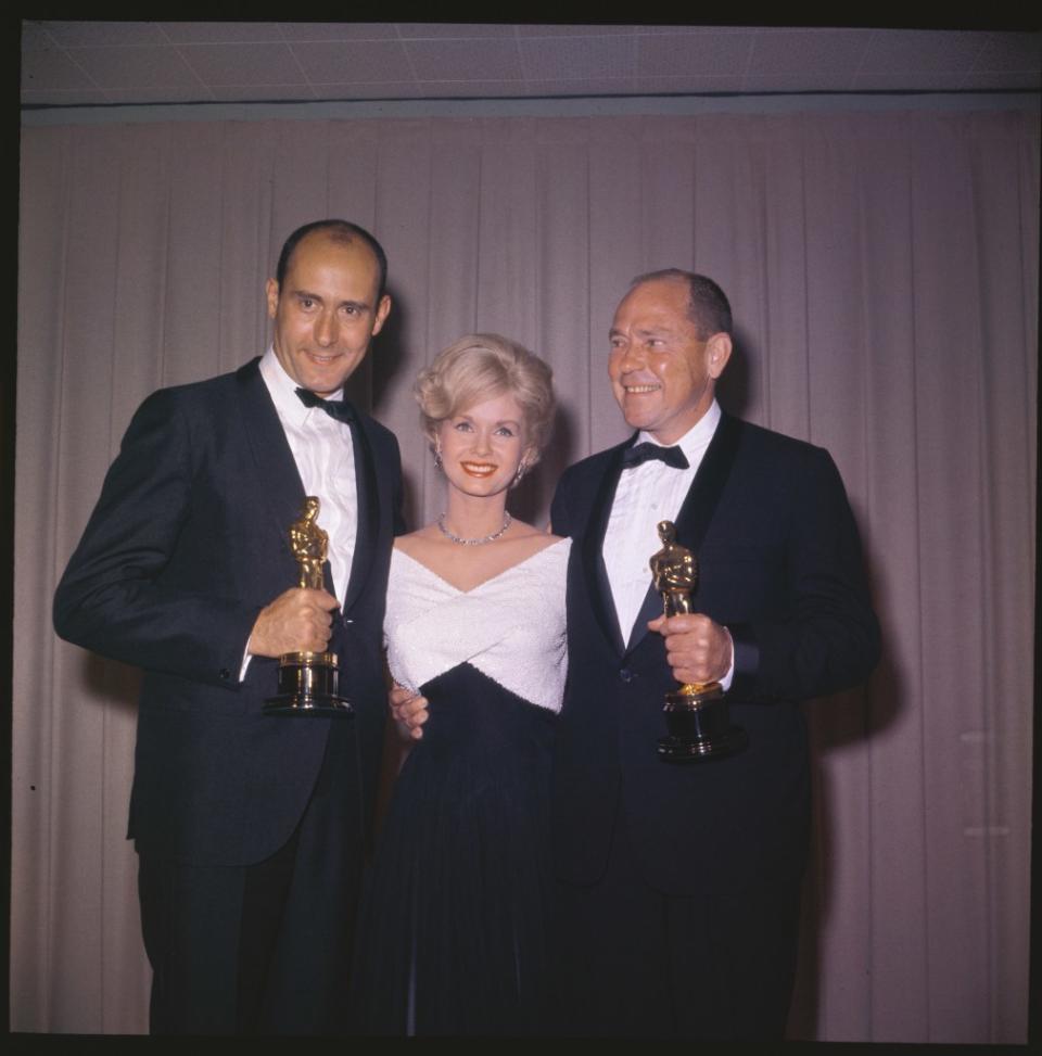 Debbie Reynolds presented Henry Mancini (left) and Johnny Mercer with their Oscar for “Moon River” in 1962. Bettmann Archive