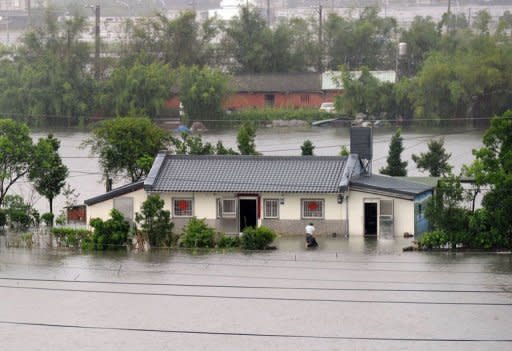 A man cleans his house at Wuche in eastern Ilan county, as typhoon Saola approches the Taiwan's east coast on August 2, 2012. As many residents across the island woke up to see their neighborhoods covered in ankle-deep water, classes and work were suspended everywhere, except for Taidong county in the southeast