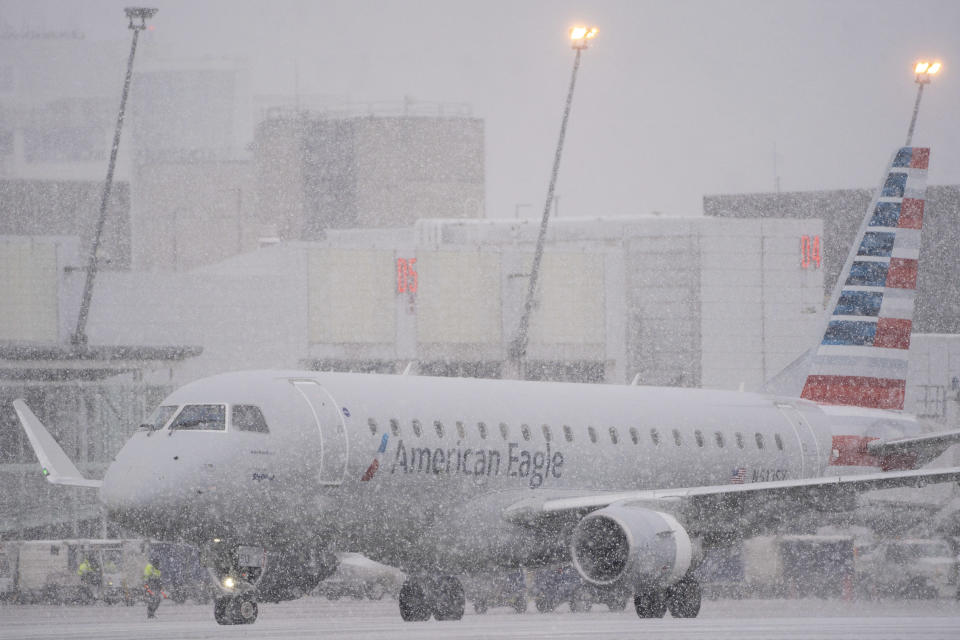 An American Eagle plane taxis during a snow storm at Seattle-Tacoma International Airport in Seattle, Washington, on Dec. 20, 2022.  / Credit: David Ryder/Bloomberg via Getty Images