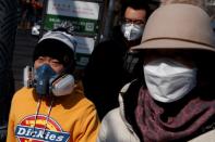 People wear face masks in a street after the novel coronavirus outbreak in Beijing