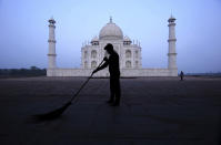 A man sweeps at the Taj Mahal monument early morning in Agra, India, Monday, Sept.21, 2020. The Taj Mahal reopened Monday after being closed for more than six months due to the coronavirus pandemic. (AP Photo/Pawan Sharma)