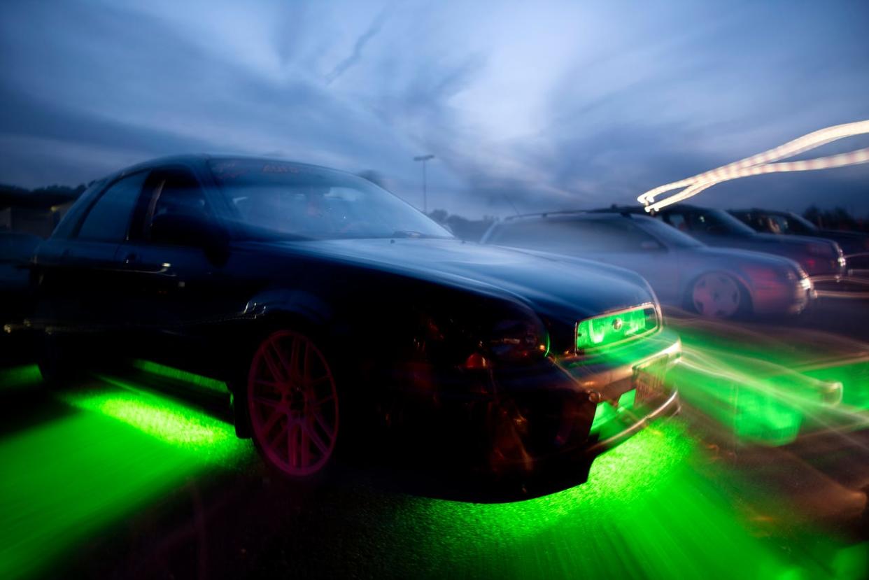 Green lights glow beneath a car during an AutoMODIFIED car club event on Aug. 25, 2019, in Battle Creek.