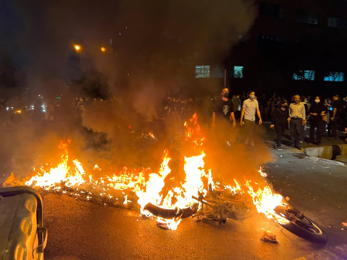 A police motorcycle burns during a protest over the death of Mahsa Amini (via REUTERS)