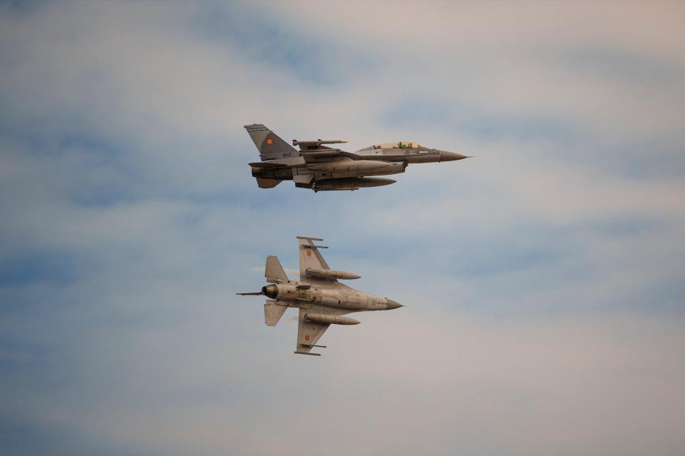 Romanian air force F-16 fighter planes fly above the Baza 86 military air base, outside Fetesti, Romania, Monday, Nov. 13, 2023.