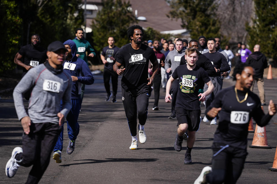 Philadelphia Police Academy applicant Curtis Cothran, center, takes part in the 1.5 mile run as part the physical fitness entry exam in Philadelphia, Saturday, Feb. 24, 2024. The city has moved to lower requirements for the entry physical exam at its police academy as part of a broader effort nationally to reevaluate policies that keep law enforcement applicants out of the job pool amid a hiring crisis. (AP Photo/Matt Rourke)