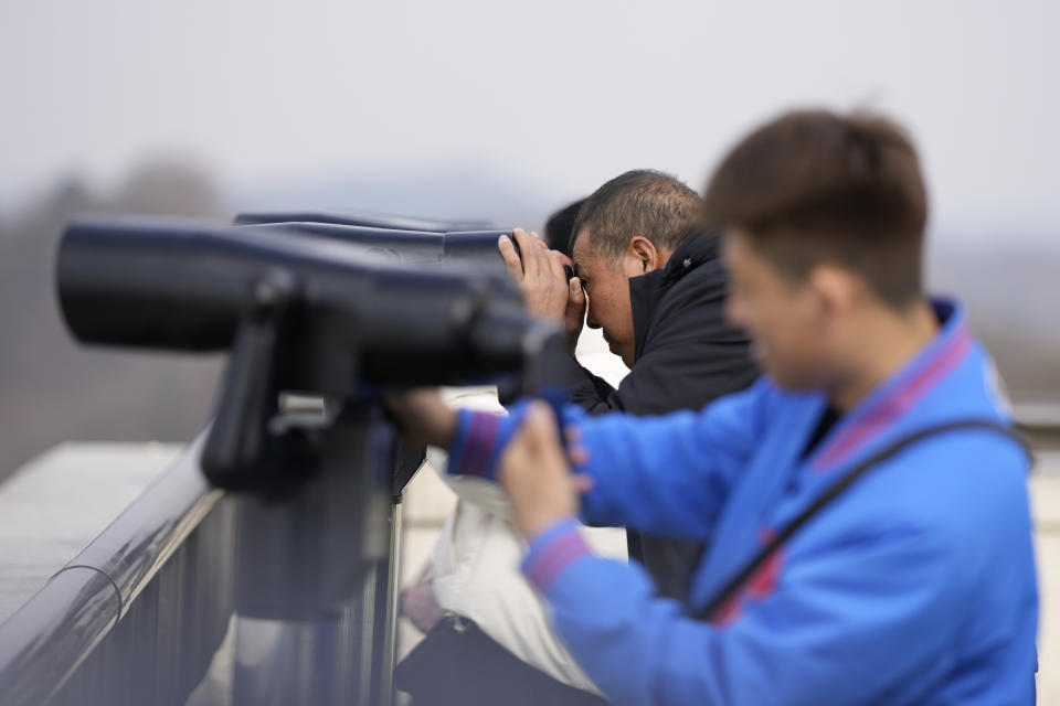 Visitors use binoculars to see the North Korean side from the unification observatory, in Paju, South Korea, Wednesday, Nov. 22, 2023. South Korea will partially suspend an inter-Korean agreement Wednesday to restart frontline aerial surveillance of North Korea, after the North said it launched a military spy satellite in violation of United Nations bans, Seoul officials said. (AP Photo/Lee Jin-man)